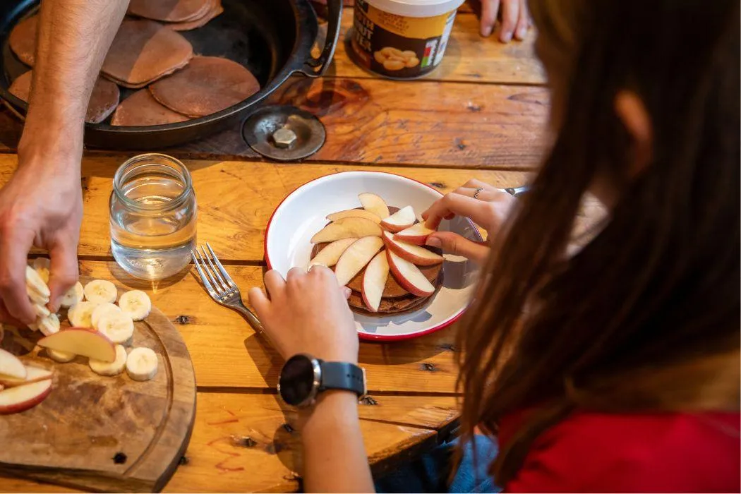 Girl eating apples prepared by her nutrition coach