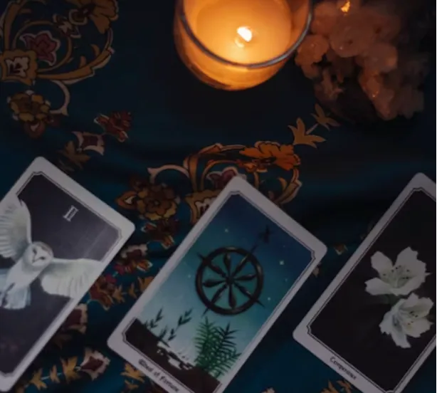 A candle and tarot cards on a table