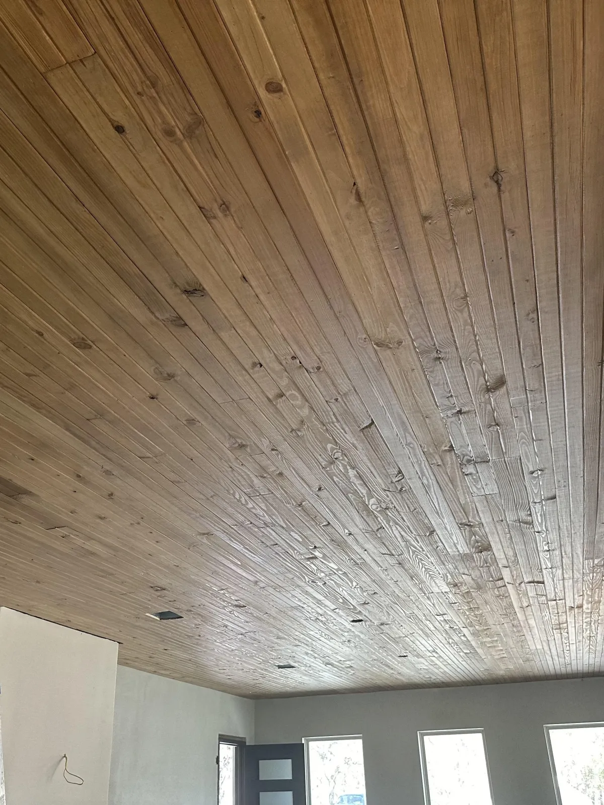 Finished wood plank ceiling detail under covered outdoor living area