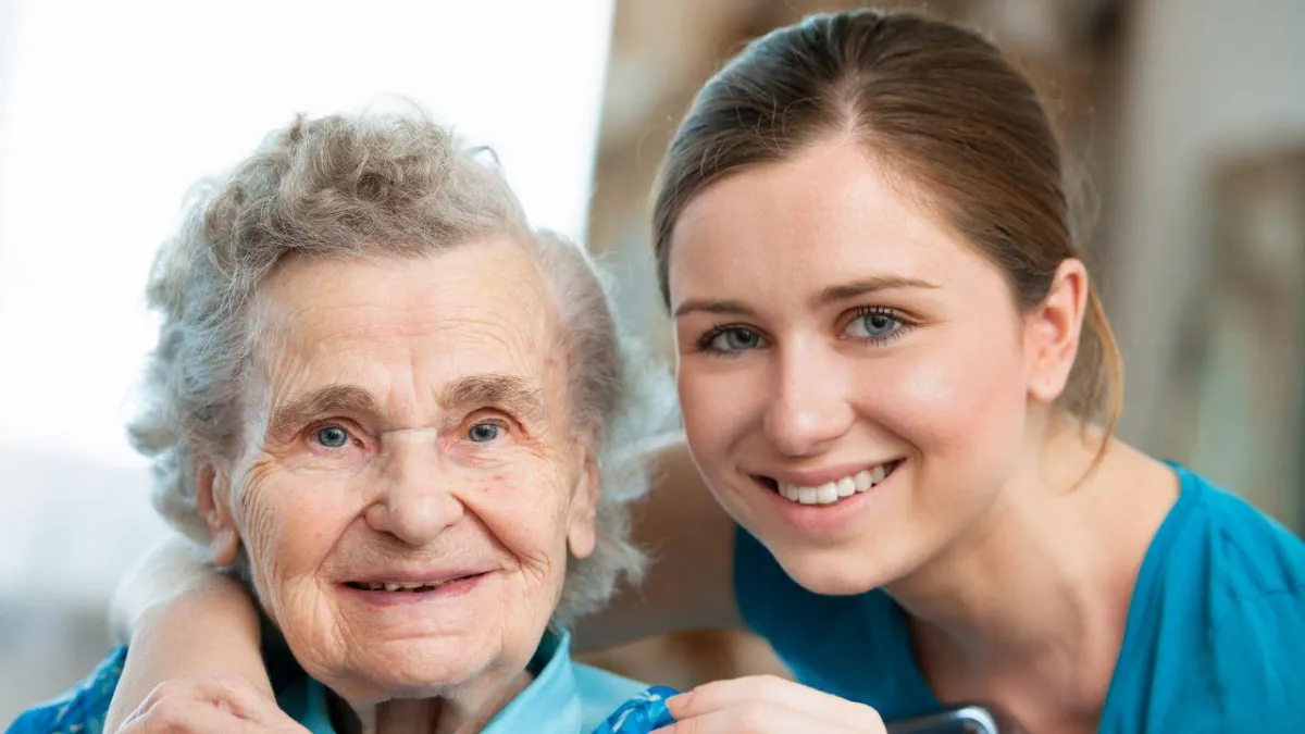 senior with her caregiver assisting in bathroom