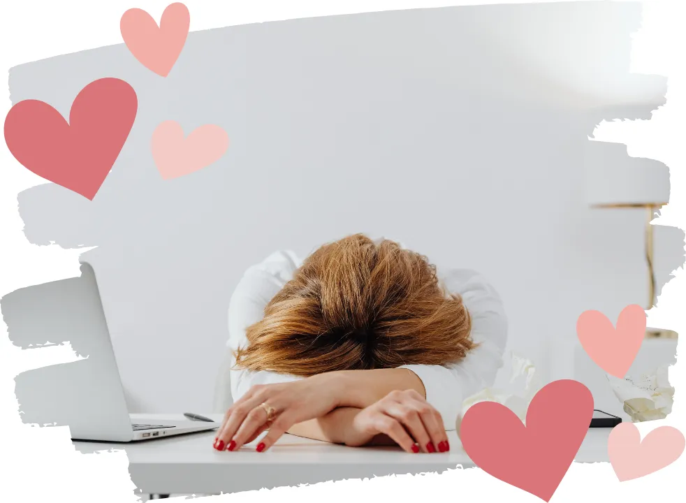 Midlife woman resting her head on her desk, looking exhausted, symbolizing perimenopause fatigue, low energy, and midlife burnout.