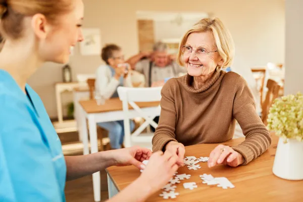 Senior smiling while working on a puzzle