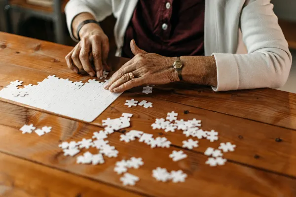 Close-up of hands placing a puzzle piece mindfully