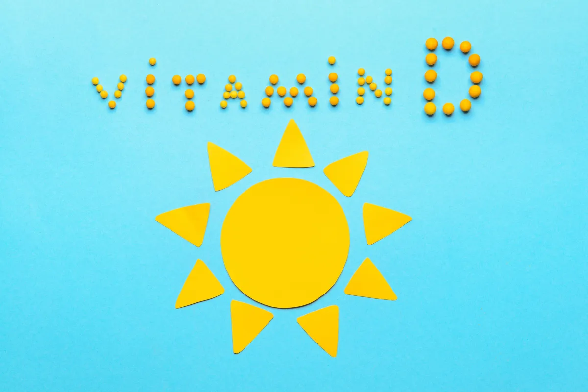 A yellow sun made from paper and stones that read vitamin D