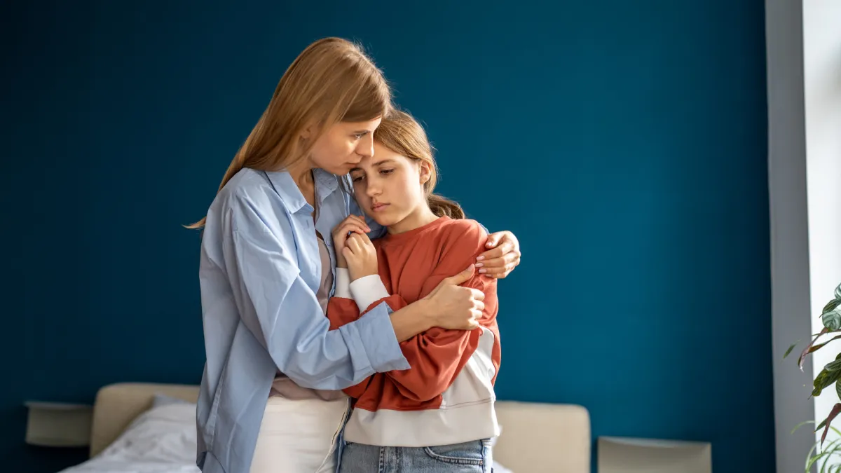 A parent providing emotional support to an anxious child, illustrating calm parenting, nervous system regulation, and connection at home.