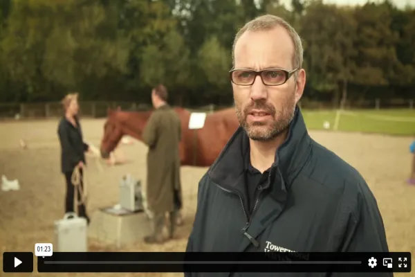 mage of a veterinarian explaining Bioresonance therapy with an attentive animal nearby