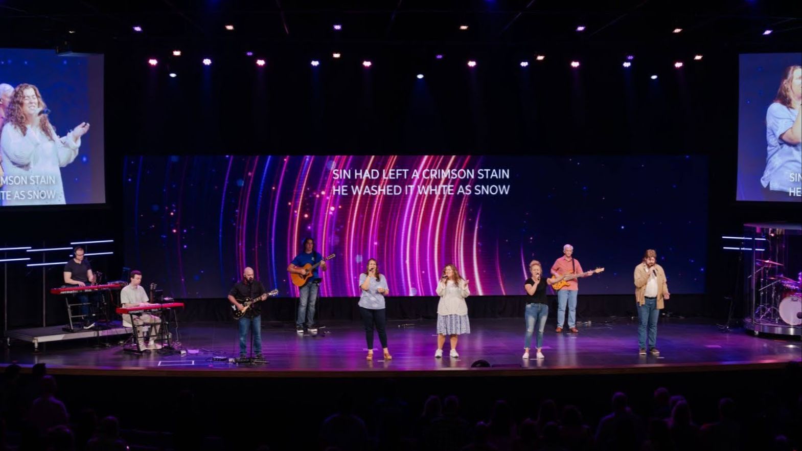 stage with led wall behind it and performers on it