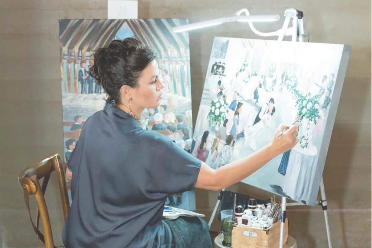 Woman sitting painting a canvas