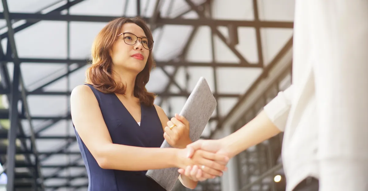 close up investor businesswoman handshake with partner vendor,collaboration of two ceo leader hand shake for agreement or b2b deal financial cooperative concept