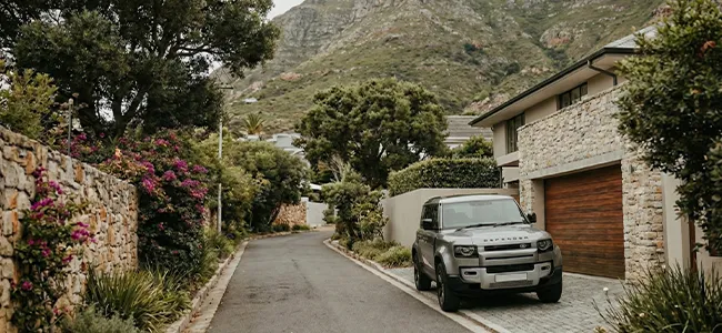An image of a fancy car standing in front of a house