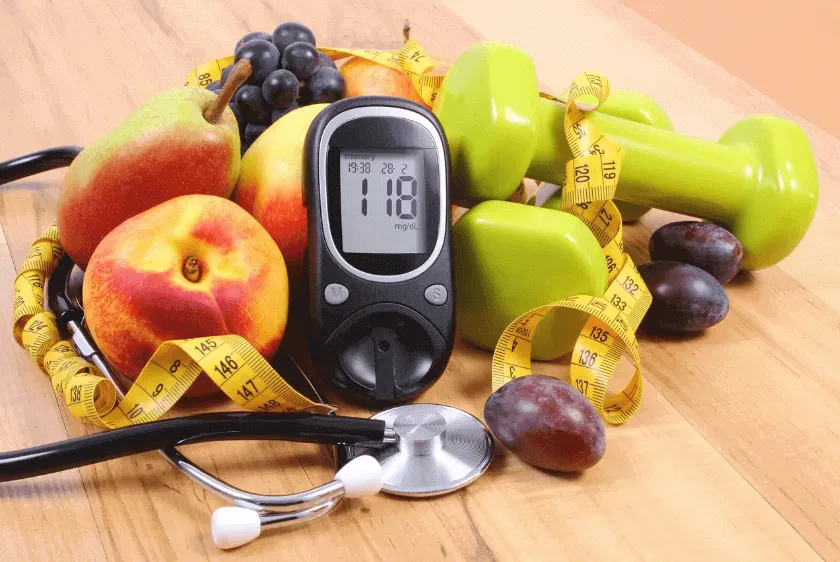 Diabetes monitor with weights and fruit and stethoscope
