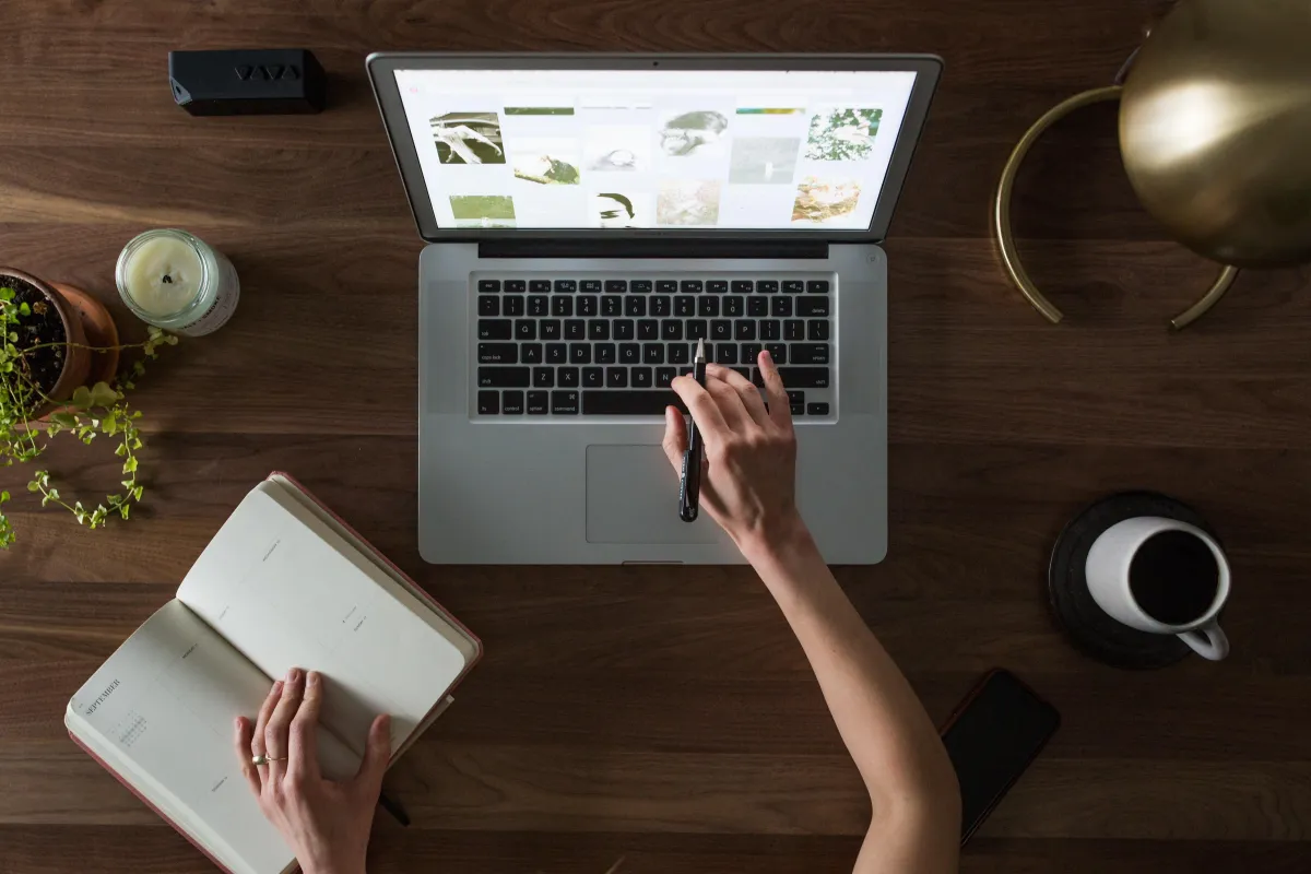 person with book and computer screen