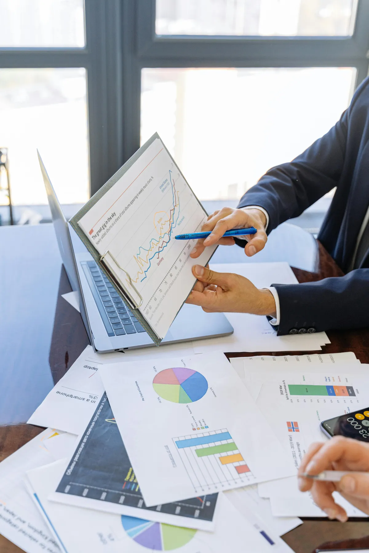 Two people looking at print outs of data with graphs and charts