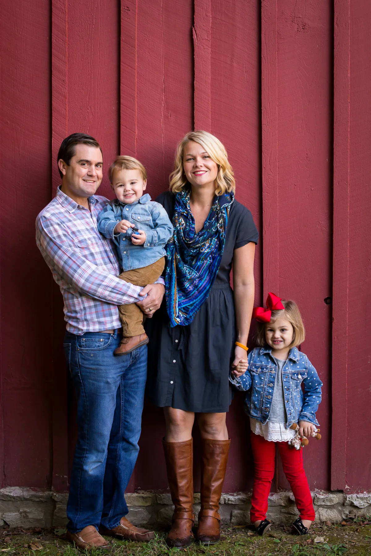 St. Louis Family Photographer mom dad sister and brother standing in front of a red barn