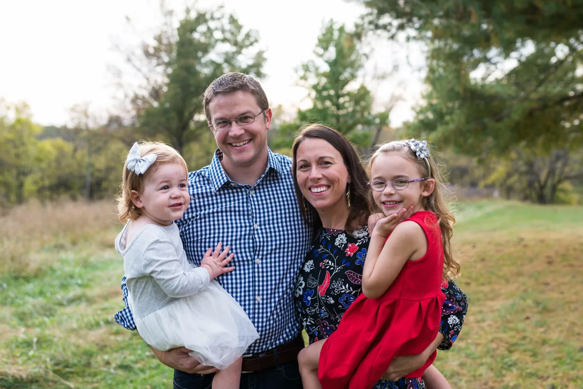 St. Louis Family Photographer mom and dad holding kids in field