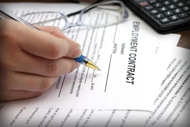 Womans hands signing an employment contract