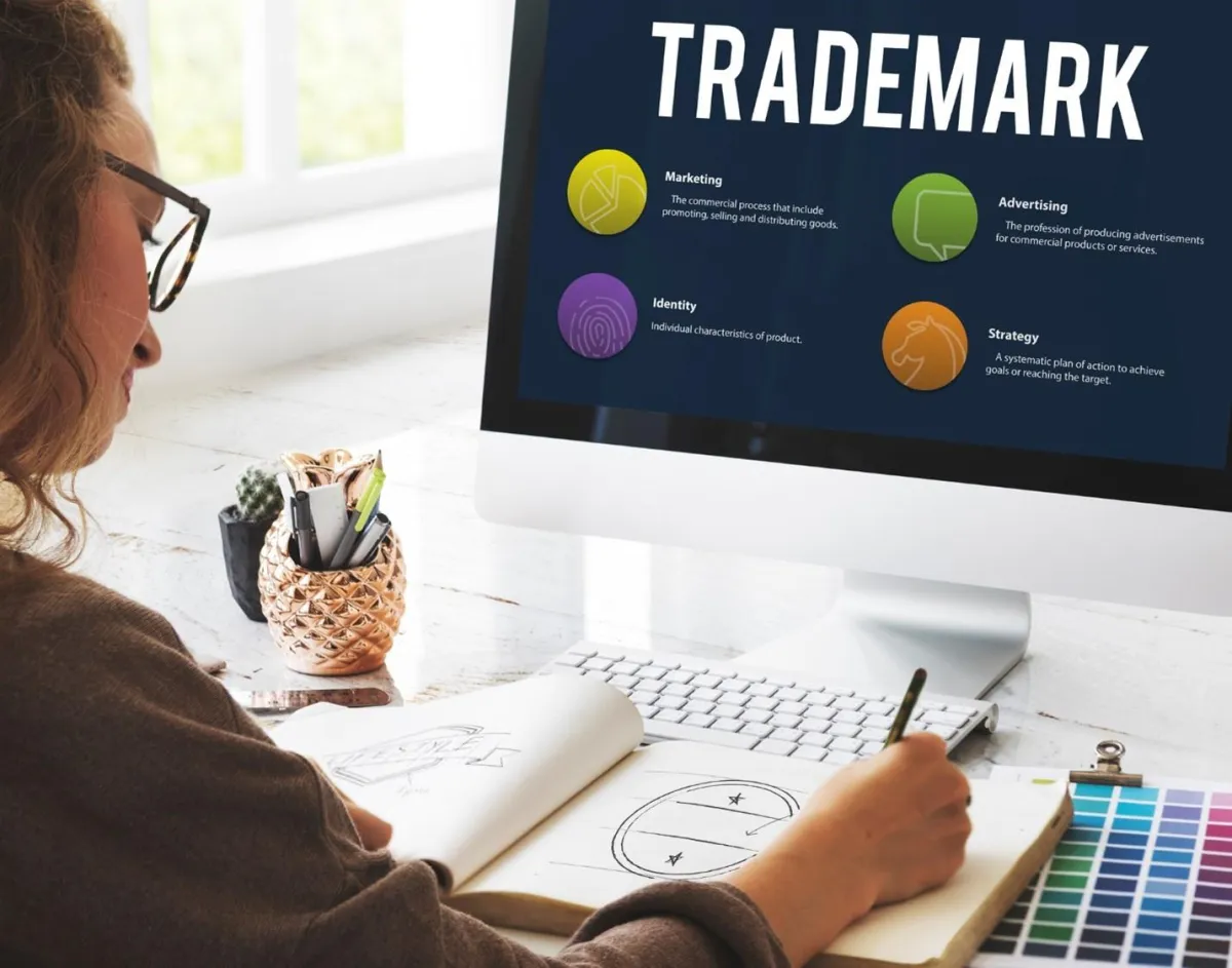 Designer drawing at a desk with “Trademark” on the computer screen 