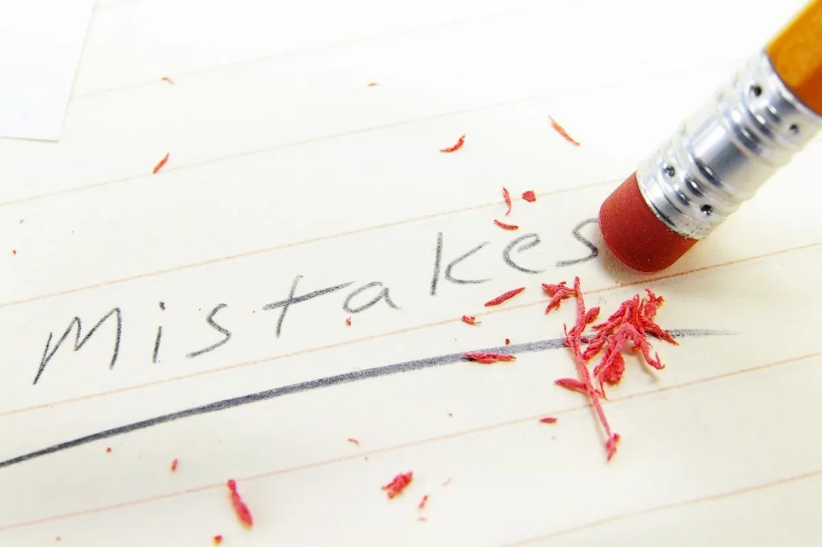 A pencil eraser next to “Mistakes” written on a sheet of paper