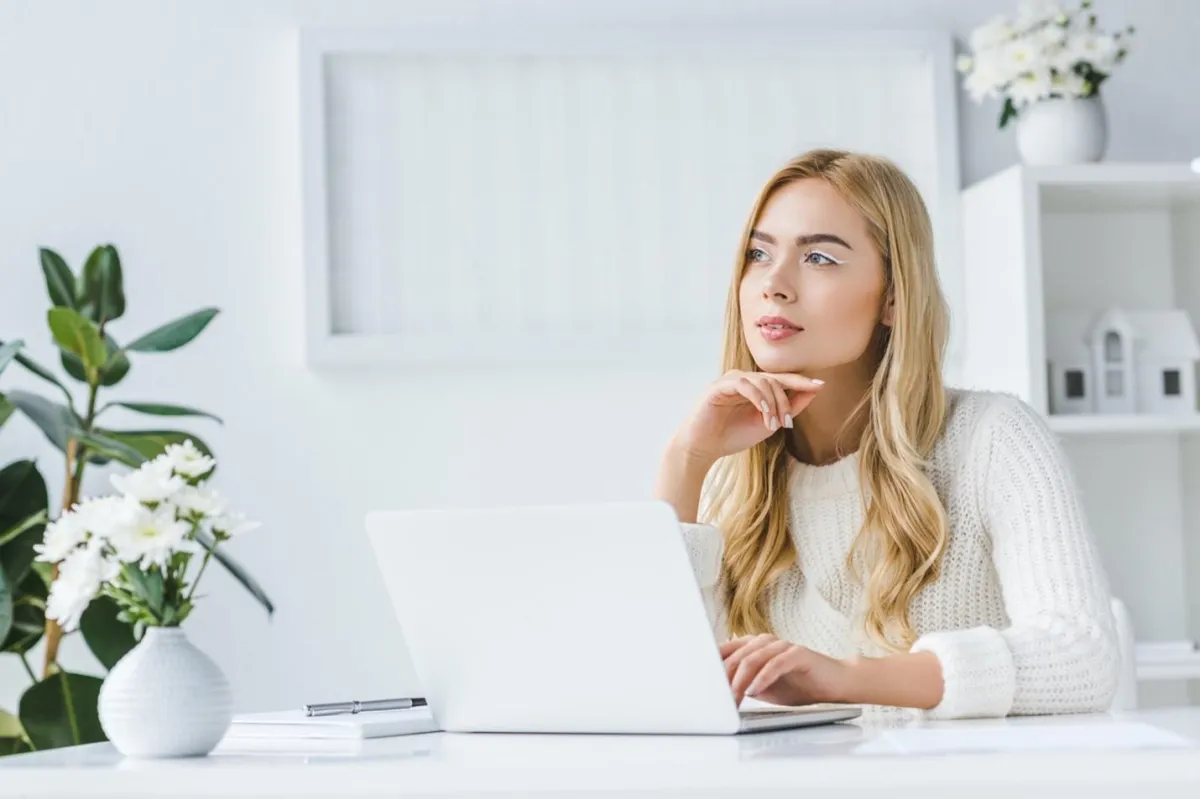 Young businesswoman at a computer considering possible domain names