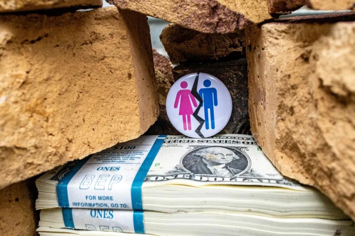 pin of divorcing couple on top of a stack of money between rocks; divorce and marital property division. Photo by Marek Studzinski on Unsplash