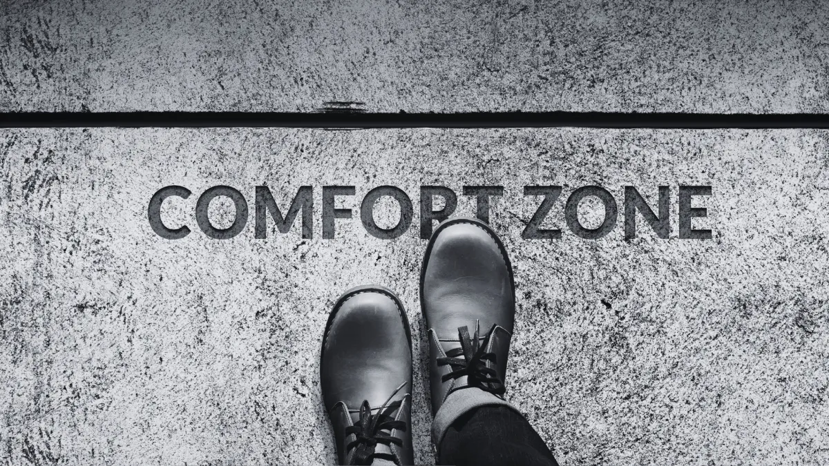 A person stands at the edge of a ground-labeled "Comfort Zone," symbolizing the step beyond one's comfort to propel a business from excellent to extraordinary with strategic micro-moves.