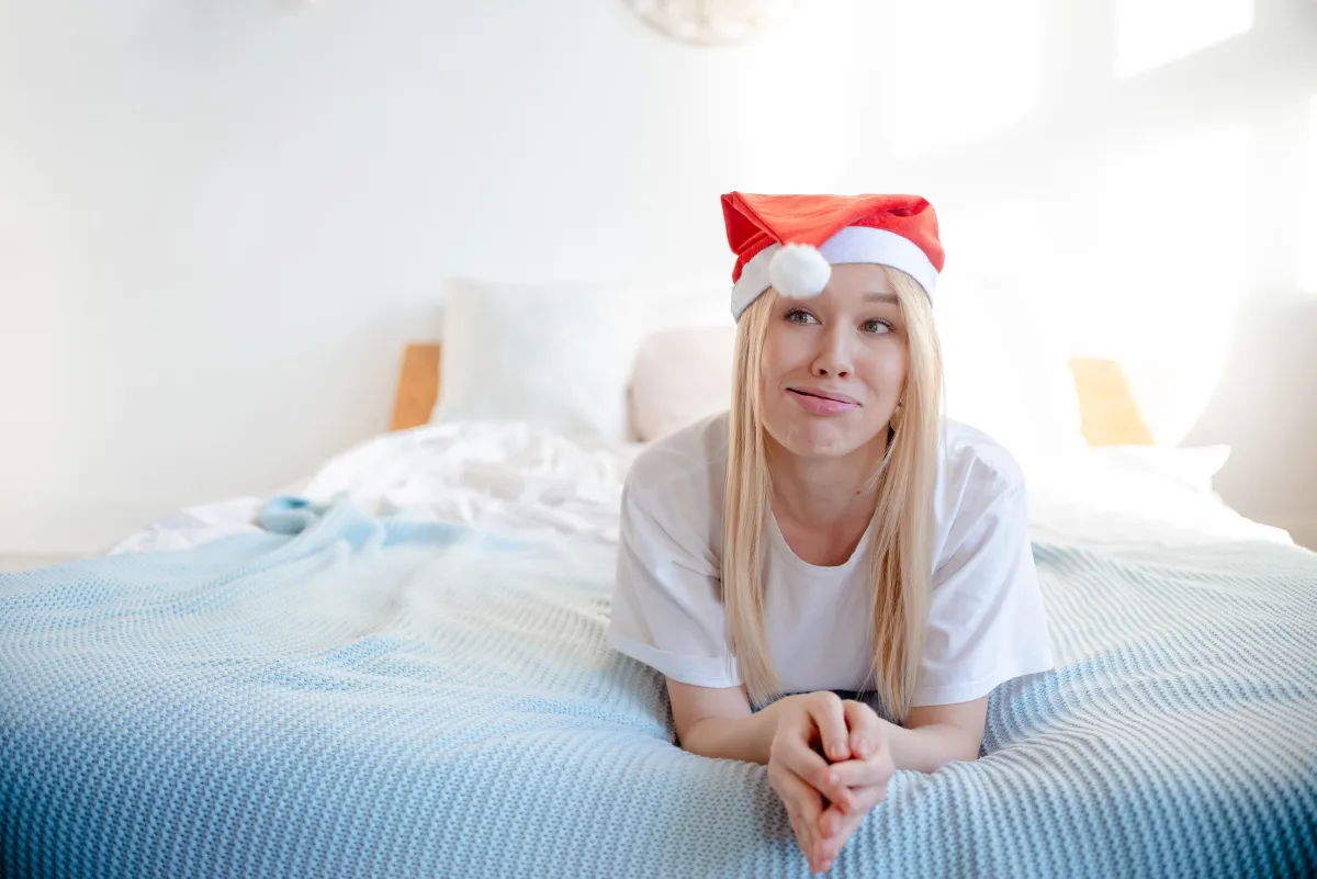 Woman on bed in a Santa hat