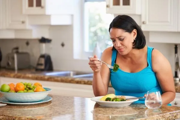 Frustrated woman eating healthy
