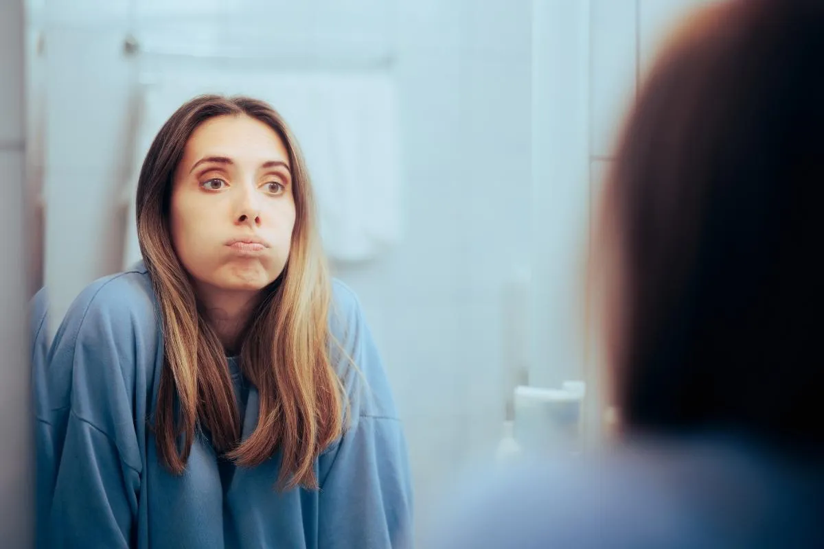 A woman looking in the mirror with judgment