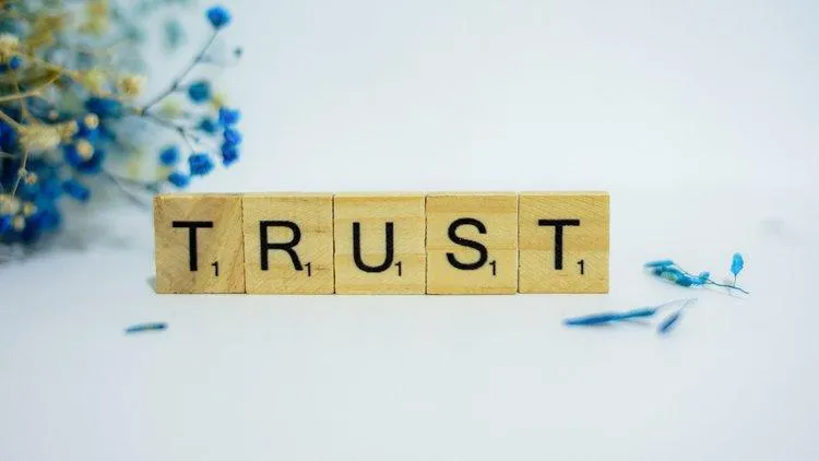 A photo of srabble blocks spelling out the word "trust"