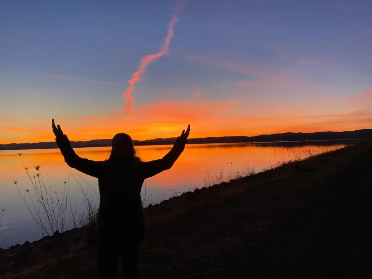 Sunset with warm orange and pink hues, symbolizing the end of a journey and the promise of new beginnings. The sky's vibrant colors evoke a sense of peace and transition, while the subtle brightness adds a hopeful touch.