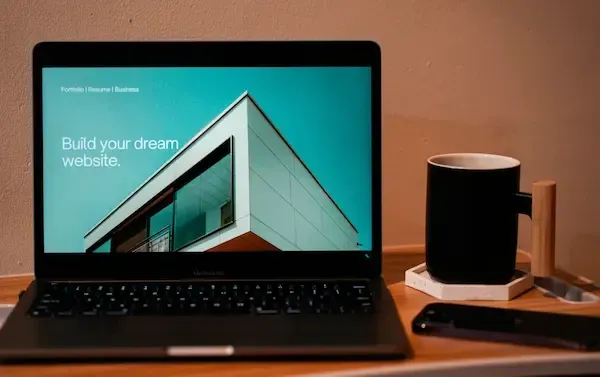 Laptop showing a modern website with the text “Build your dream website,” next to a coffee mug — representing professional web design by Golden Wheel Marketing in New Jersey.