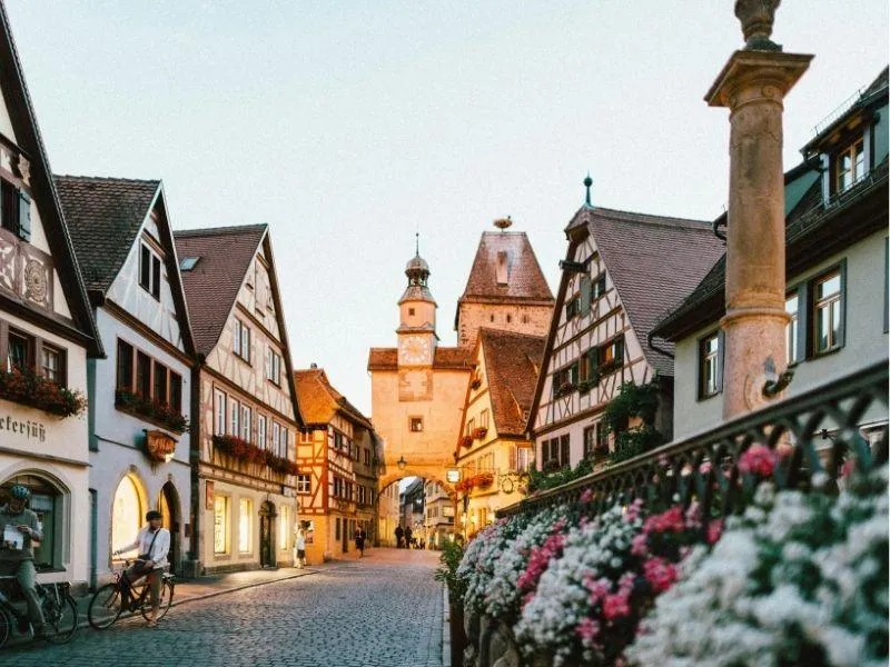 Old European town with timber-framed houses and an arched gateway topped by a bell tower