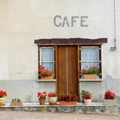Door to an old cafe with flowers in front.