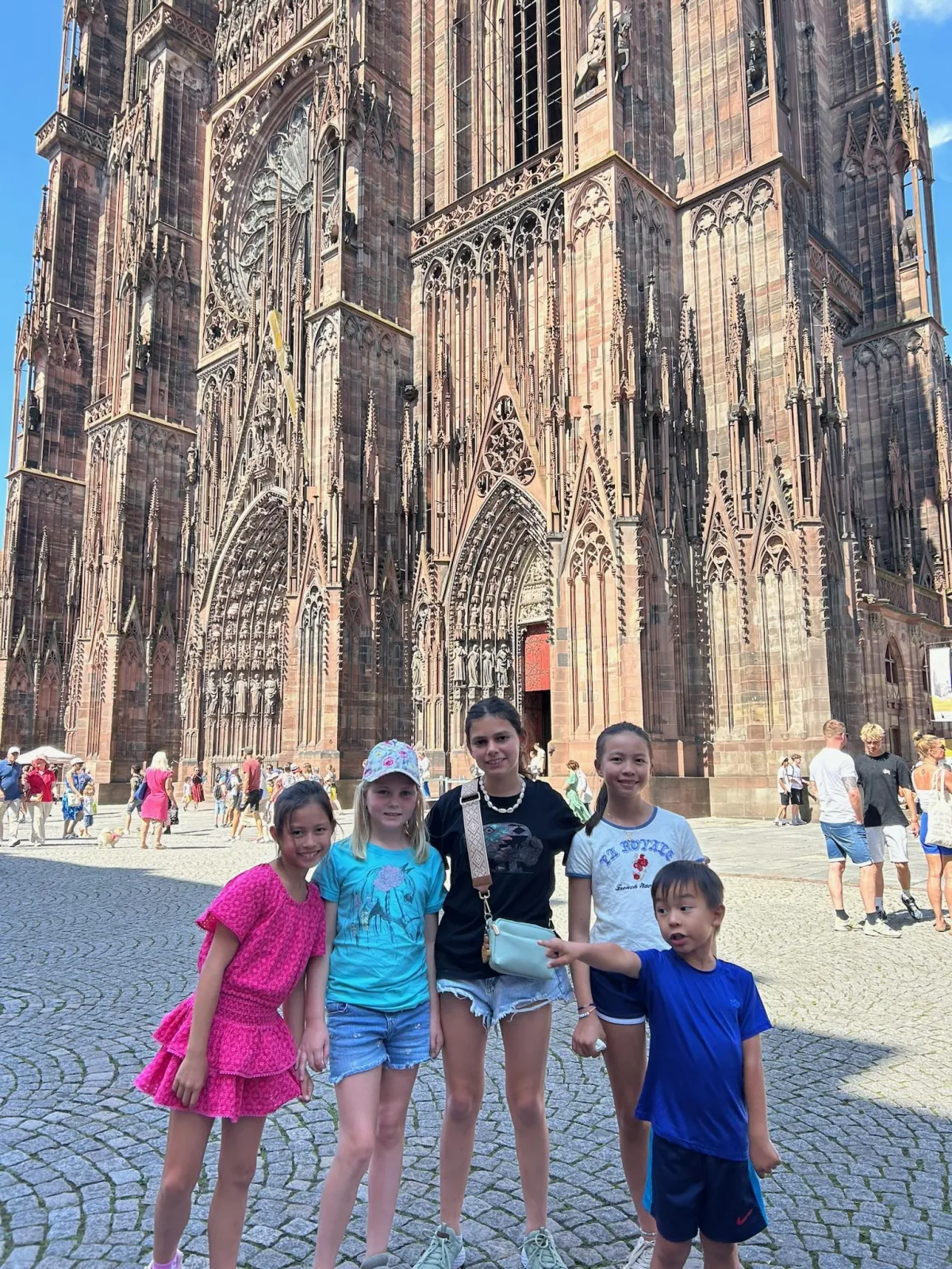 Children posing in front of a historic European church during a family trip