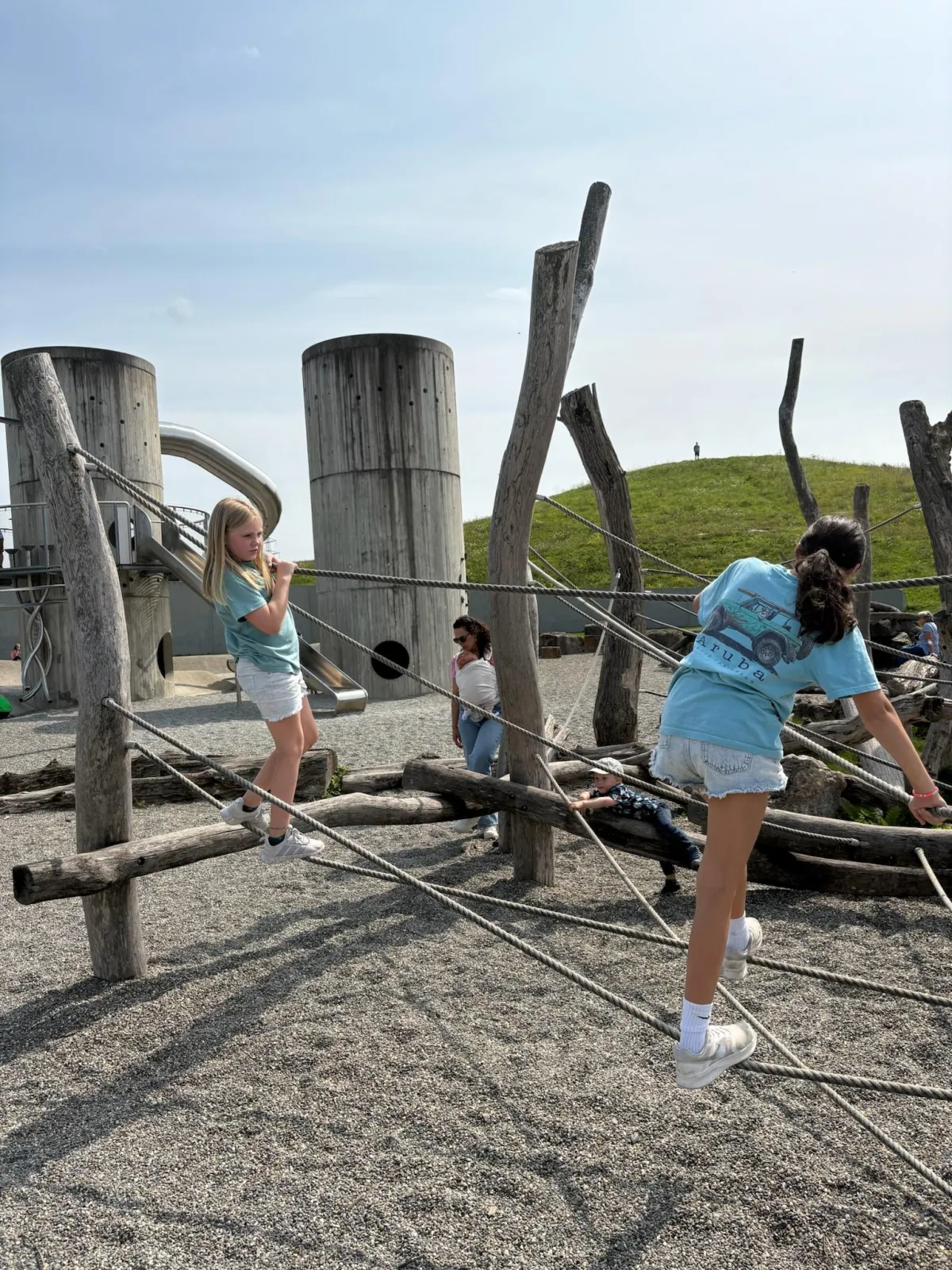 Two girls playing together on a playground during a European family vacation