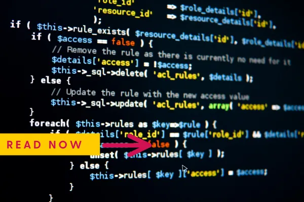 Beginner building a website on a laptop using drag-and-drop builder, with coffee and phone on desk