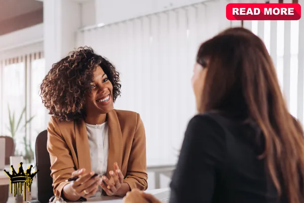 Two women discussing on-page and technical SEO strategies in a modern workspace, with a laptop open on the table.