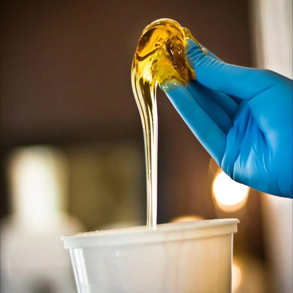 Close-up of warm, golden sugaring paste ready for application