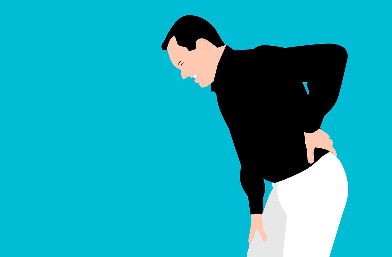 Man holding his lower back in pain, symbolizing the discomfort caused by a bulging disc, as discussed in The Disc Doctor's comprehensive guide on spinal health.