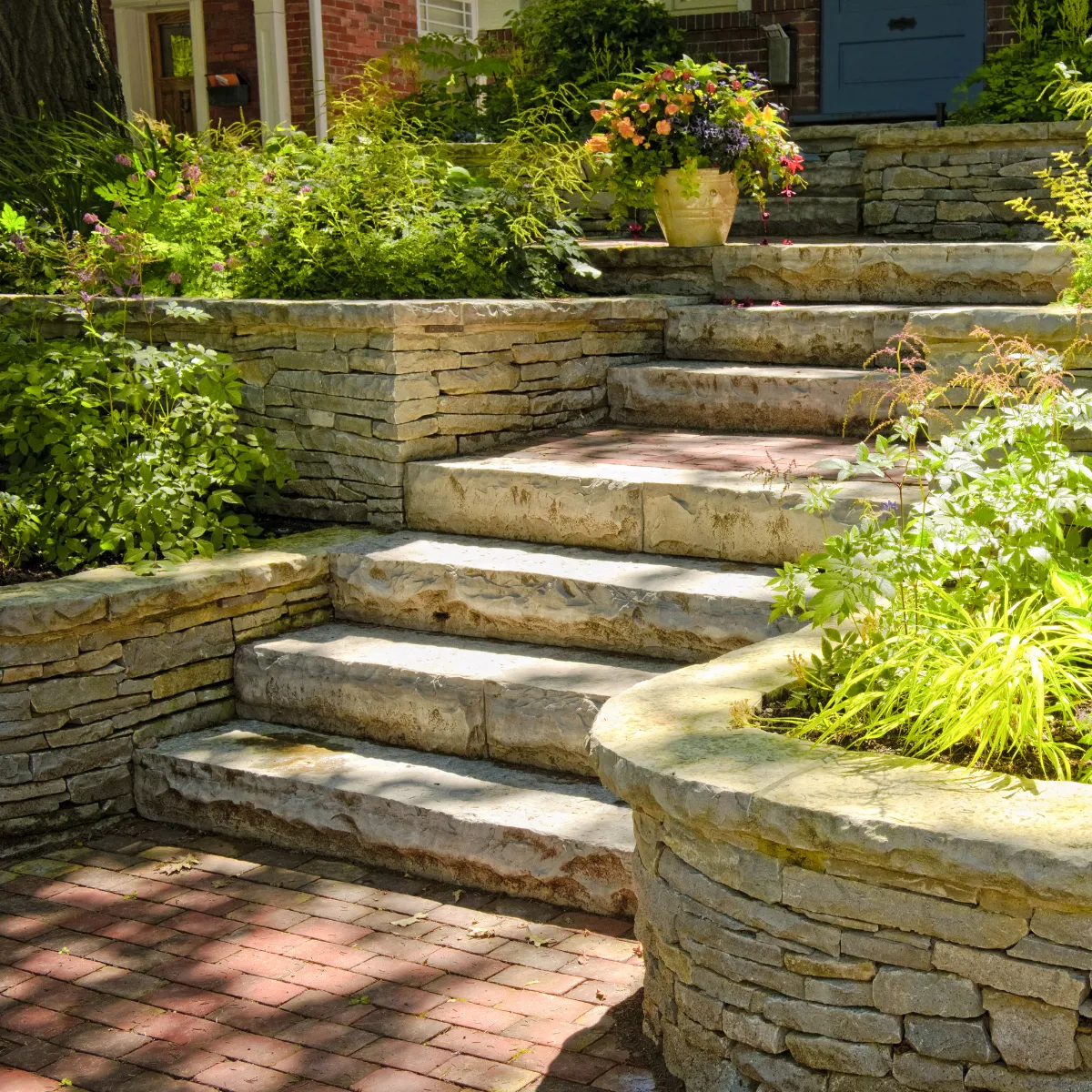 Stone steps and curved retaining wall with landscaping built for backyard hardscaping project