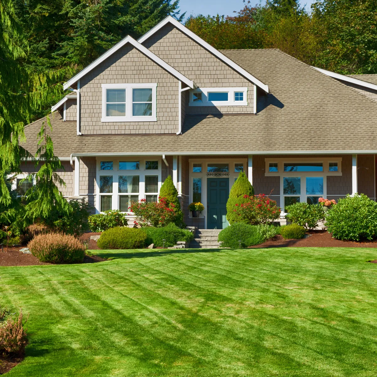 Front view of remodeled home with new siding, landscaping, and perfectly maintained lawn
