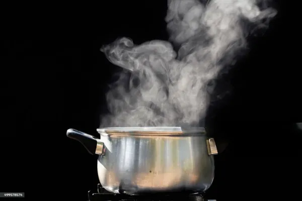 Proceso de agua hirviendo en una olla transparente sobre estufa, mostrando burbujas formándose activamente. Método casero de purificación de agua para eliminar bacterias y microorganismos nocivos.