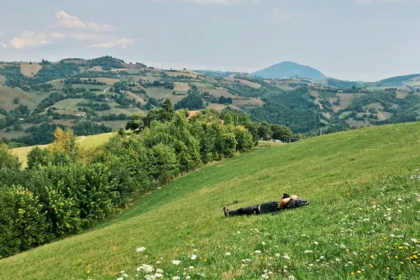 man-resting-on-hillside-staring-at-sky