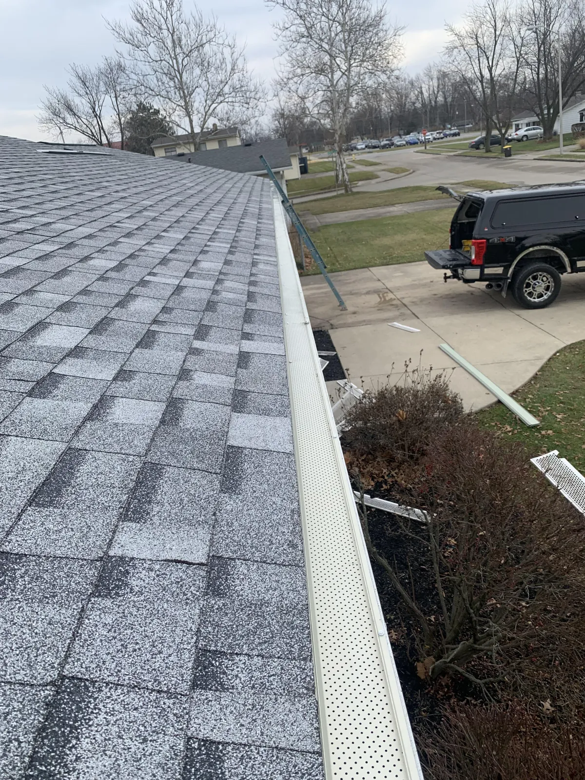 Close-up of clean white house gutters directing rainwater away from the roofline to protect the home.