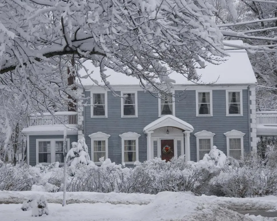 Snow-covered roof on a Fort Wayne home, showing winter conditions that can cause ice dams, leaks, and shingle damage.