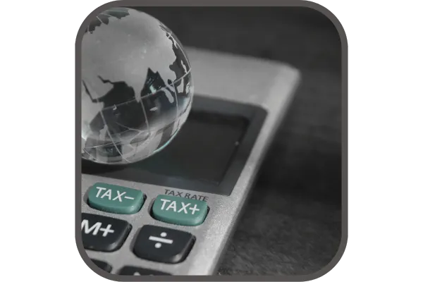 A globe on a calculator with the word tax