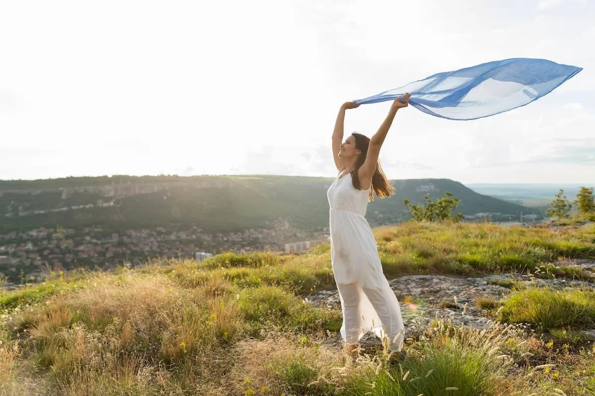 a women raising her shoal and feeling the scenery after a new found freedom in life