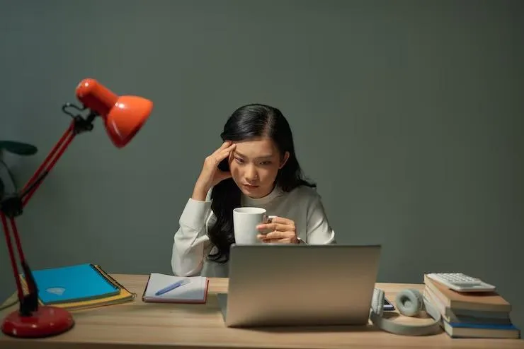 female office worker staring at her laptop frustrated about work