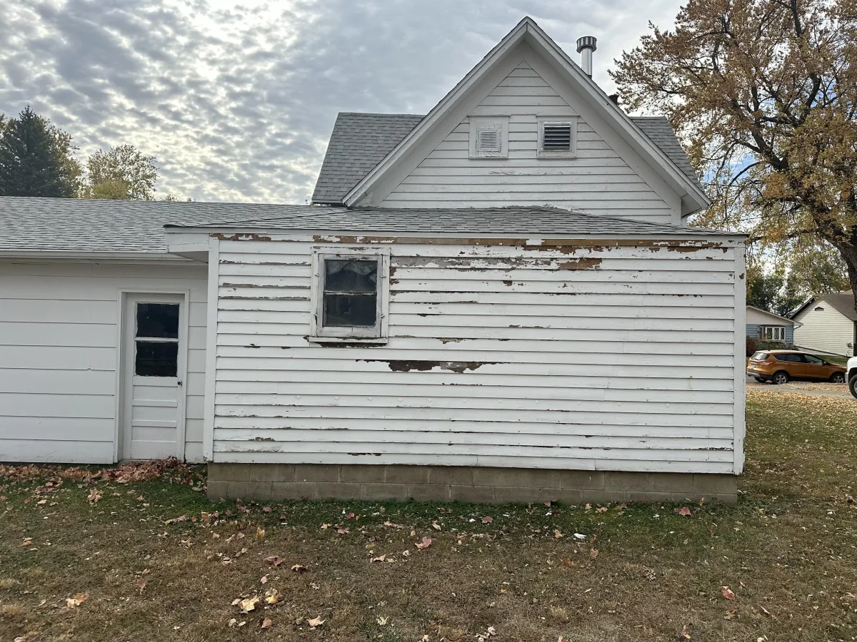Before repaint: patchy and worn exterior with weather-damaged siding