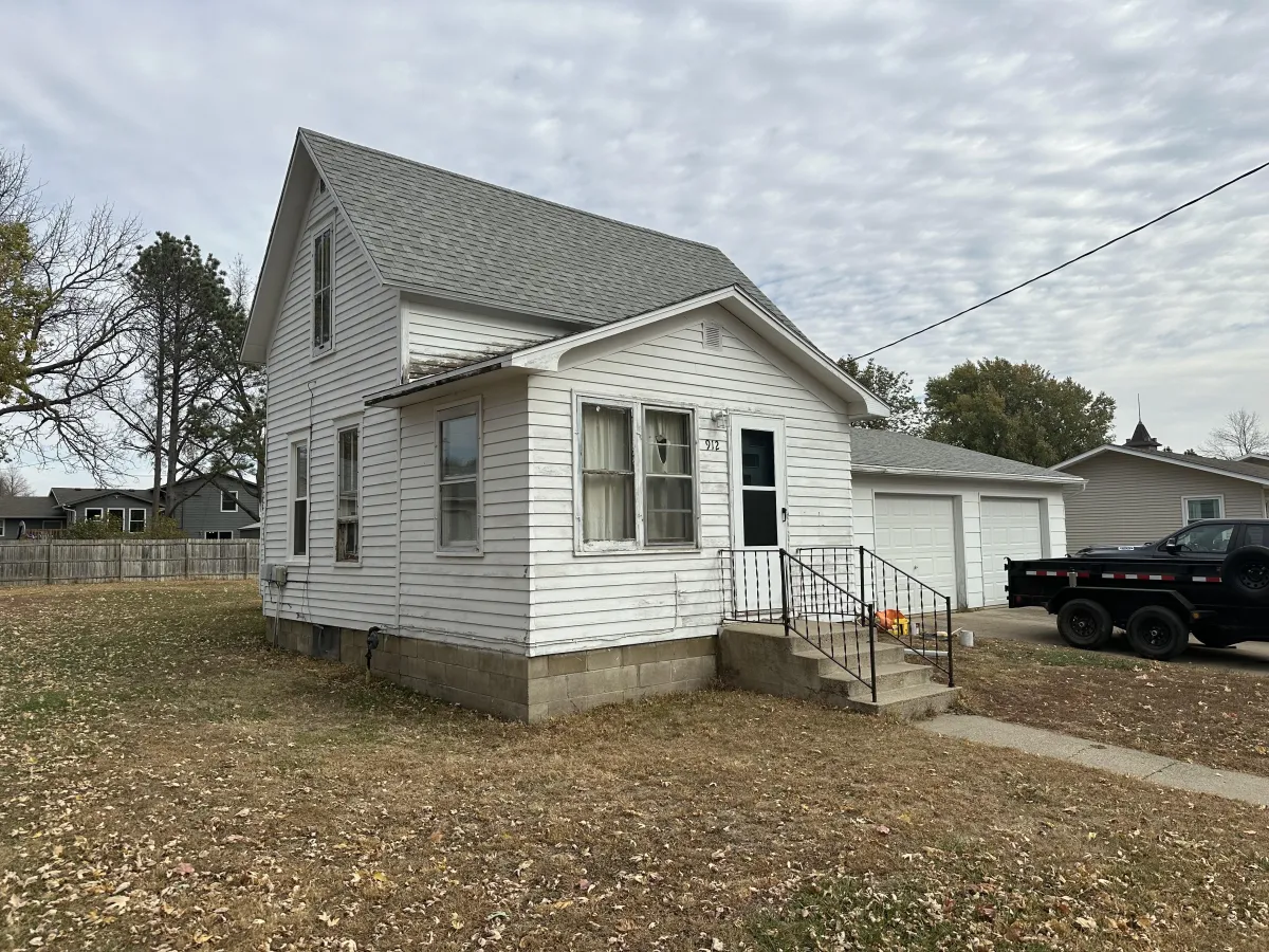 Before exterior repaint: faded trim and dull siding on residential home